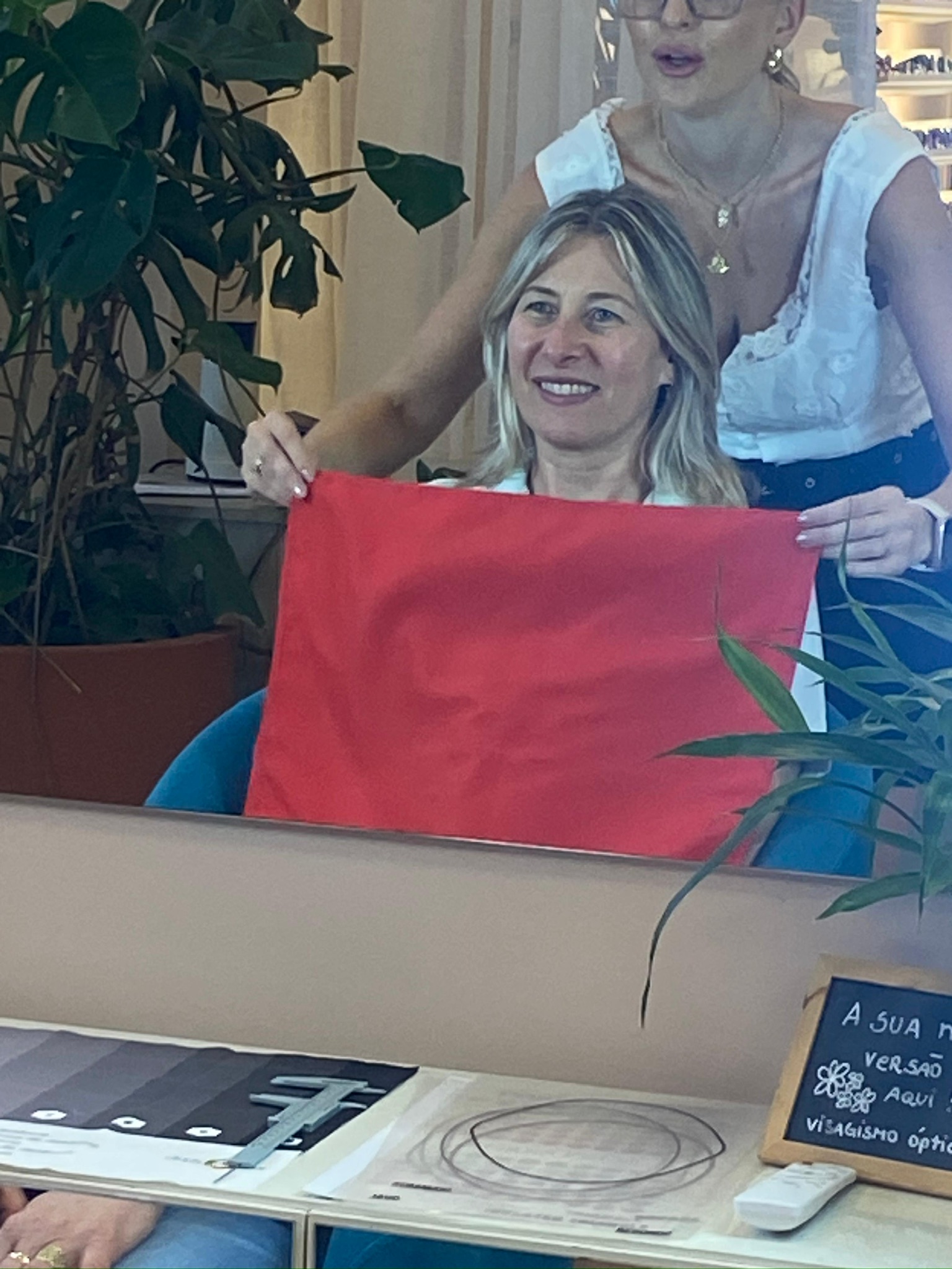 Giovana Suss usando um tecido vermelho durante a análise de cores de uma cliente
