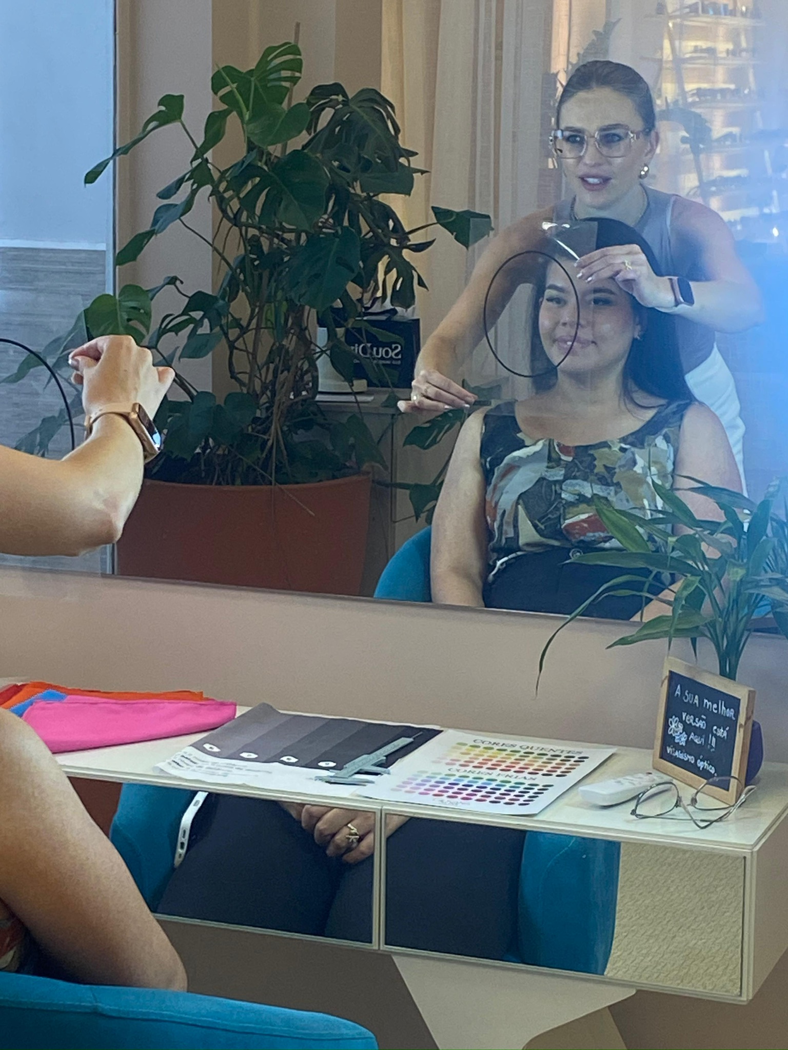 Giovana Suss realizando uma análise facial com uma cliente diante do espelho